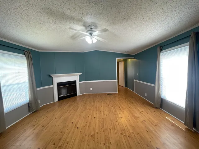 a view of empty room with wooden floor and fireplace
