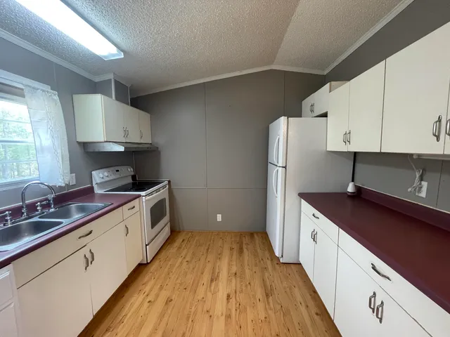 a kitchen with stainless steel appliances a sink cabinets and wooden floor