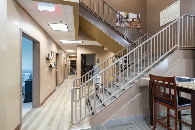 a room with lots of white furniture and a wooden floor