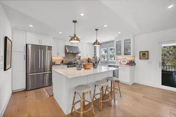 a kitchen with stainless steel appliances kitchen island granite countertop a refrigerator and a stove top oven