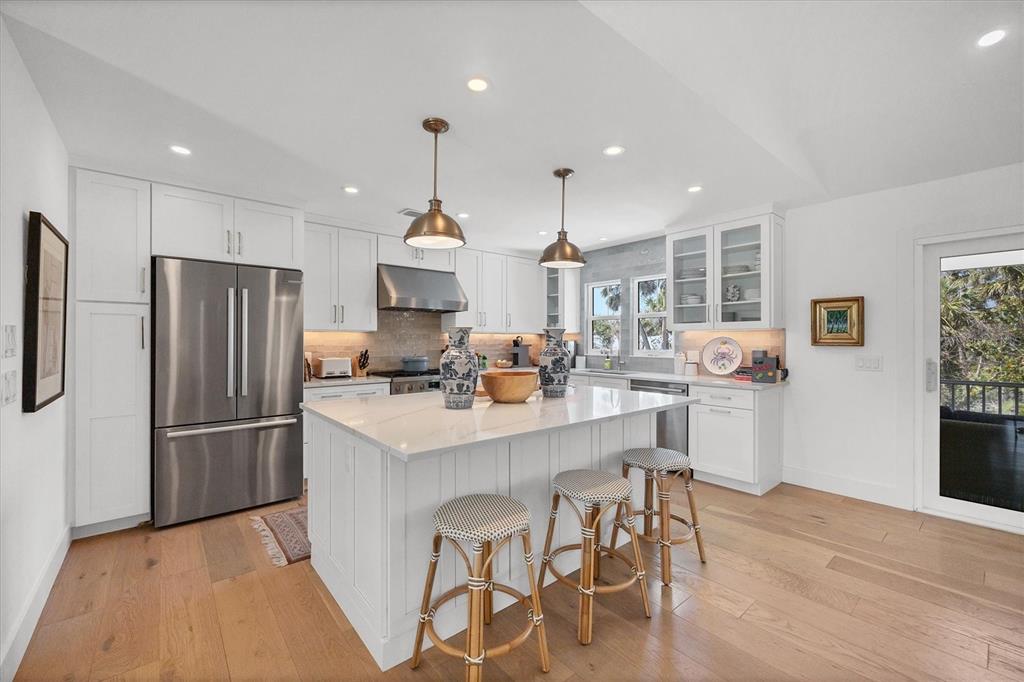355 Barbarossa Street Boca Grande, FL 33921 - Photo 12 of 47 a kitchen with stainless steel appliances kitchen island granite countertop a refrigerator and a stove top oven
