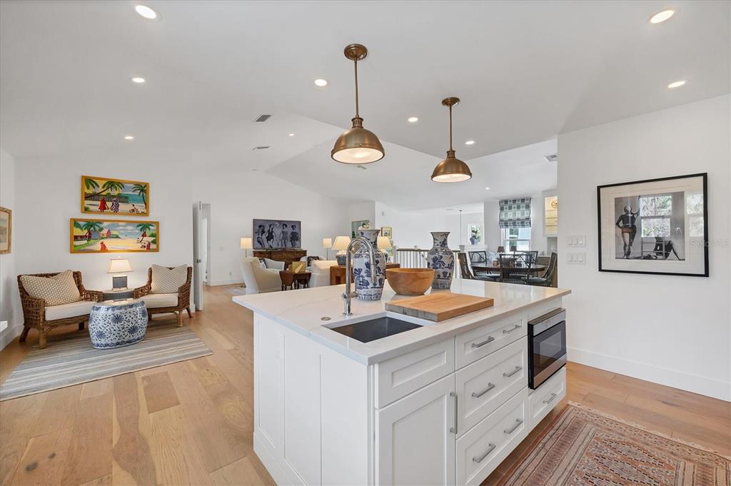 355 Barbarossa Street Boca Grande, FL 33921 - Photo 15 of 47 a kitchen with stainless steel appliances kitchen island granite countertop a sink and white cabinets with wooden floor