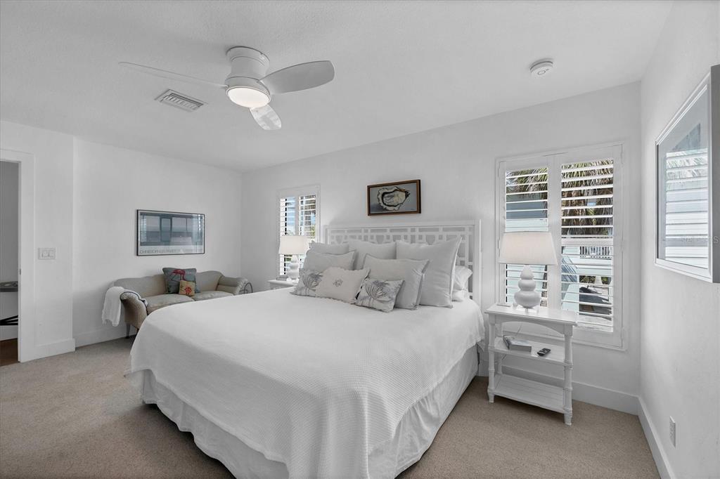 355 Barbarossa Street Boca Grande, FL 33921 - Photo 20 of 47 a bedroom with a large bed and a chandelier