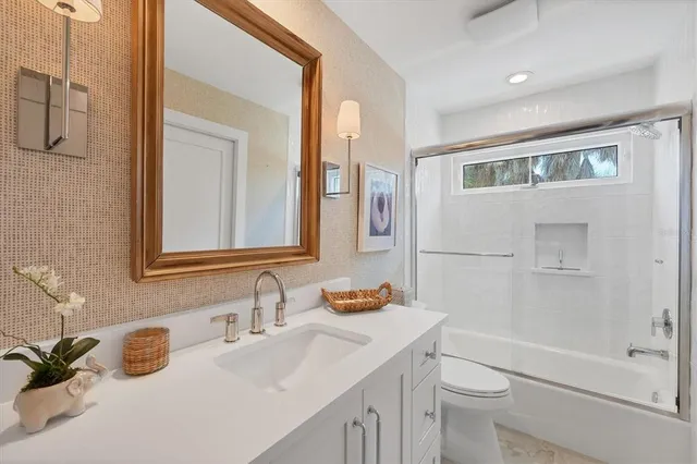 a bathroom with a sink toilet tub and shower