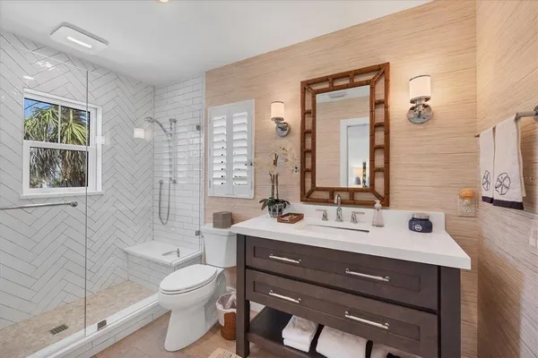 a bathroom with a double vanity sink toilet mirror and shower