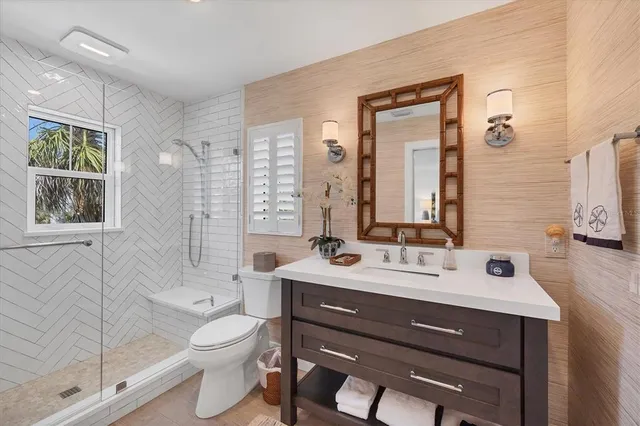 a bathroom with a double vanity sink toilet mirror and shower
