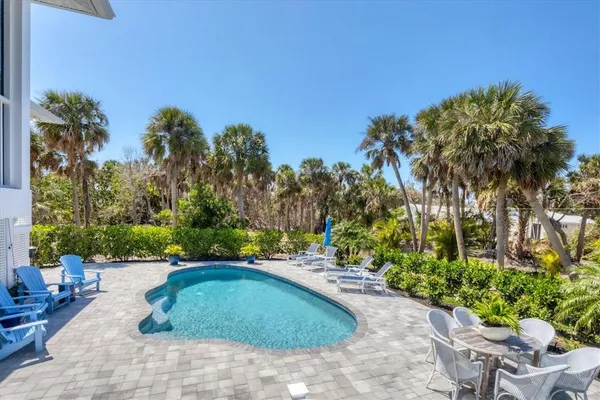 a swimming pool with outdoor seating and plants