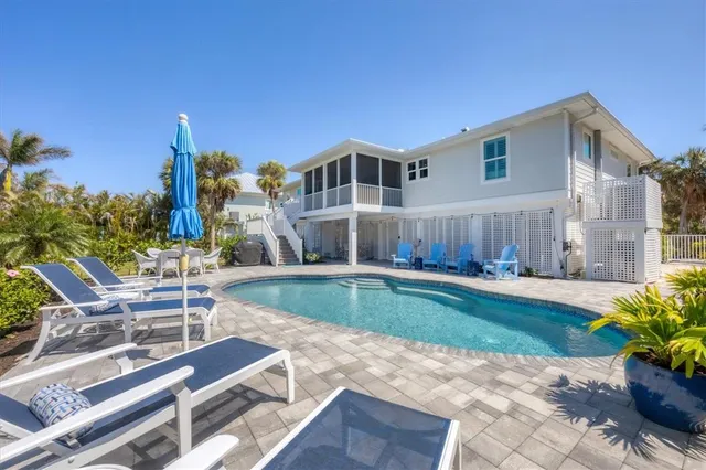 a view of a house with backyard and sitting area