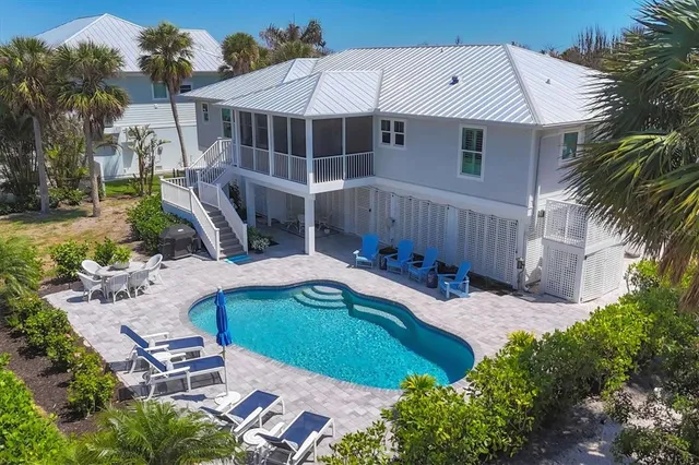 a aerial view of a house with backyard and trees