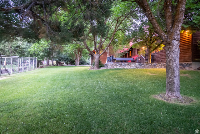 435 Canyon Road Millville, UT 84326 - Photo 61 of 113 Expansive lawn area featuring mature trees and a stone-clad retaining wall