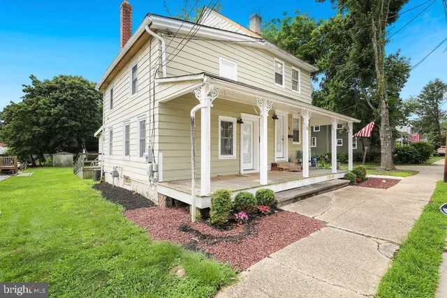 a front view of a house with a garden and plants