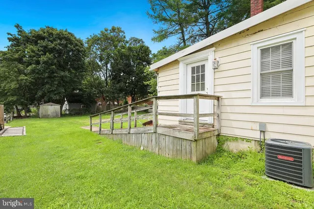 a view of a house with backyard and a tree