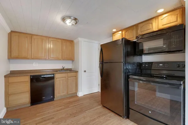 a kitchen with a refrigerator stove and wooden cabinets