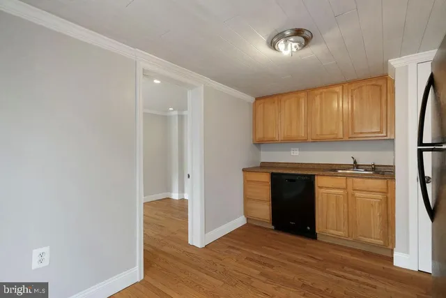 a kitchen with granite countertop a stove cabinets and wooden floor
