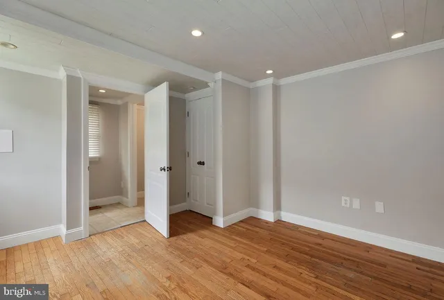 a view of empty room with wooden floor