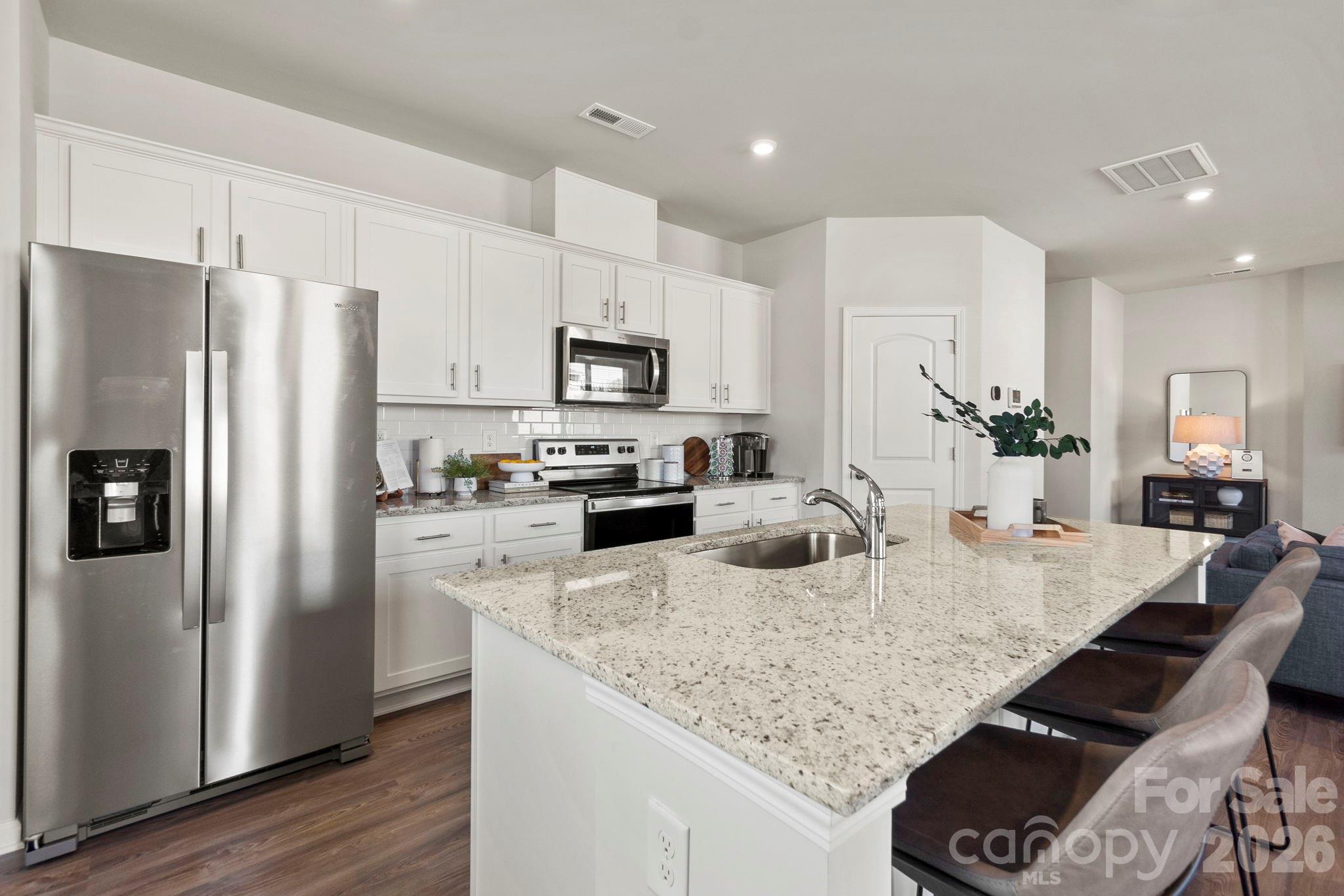 8034 Midas Lane Locust, NC 28097 - Photo 11 of 27 a kitchen with stainless steel appliances granite countertop a refrigerator a stove top oven a sink and dishwasher