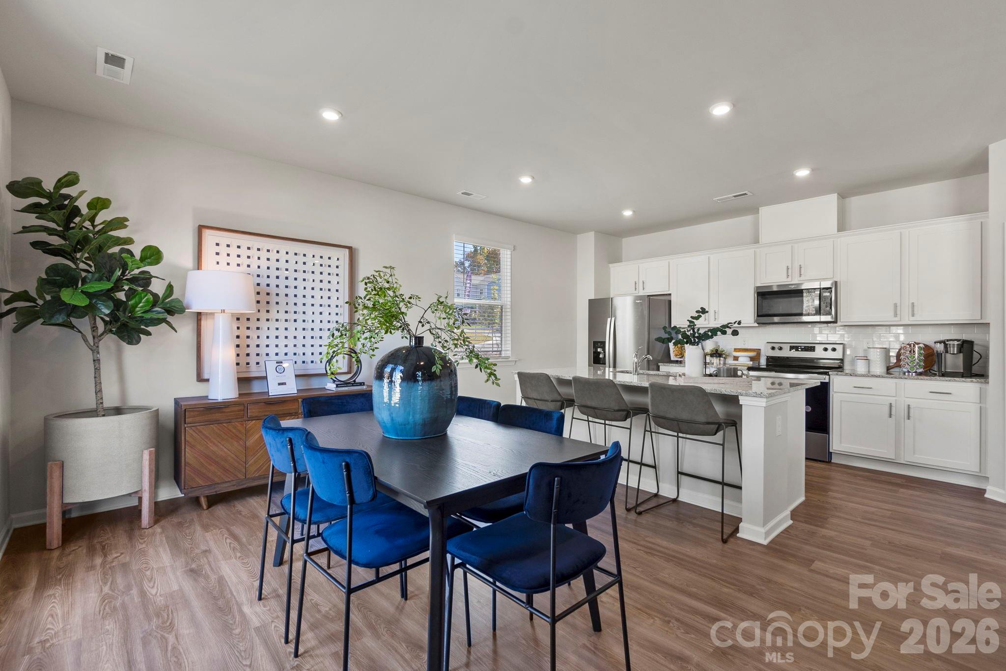 8034 Midas Lane Locust, NC 28097 - Photo 14 of 27 a kitchen with a dining table chairs and refrigerator
