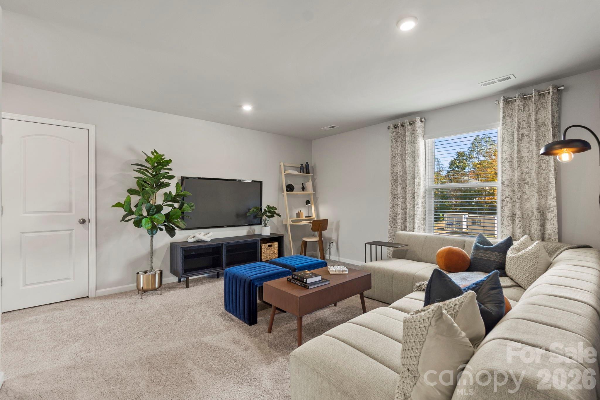 8034 Midas Lane Locust, NC 28097 - Photo 22 of 27 a living room with furniture a window and a flat screen tv