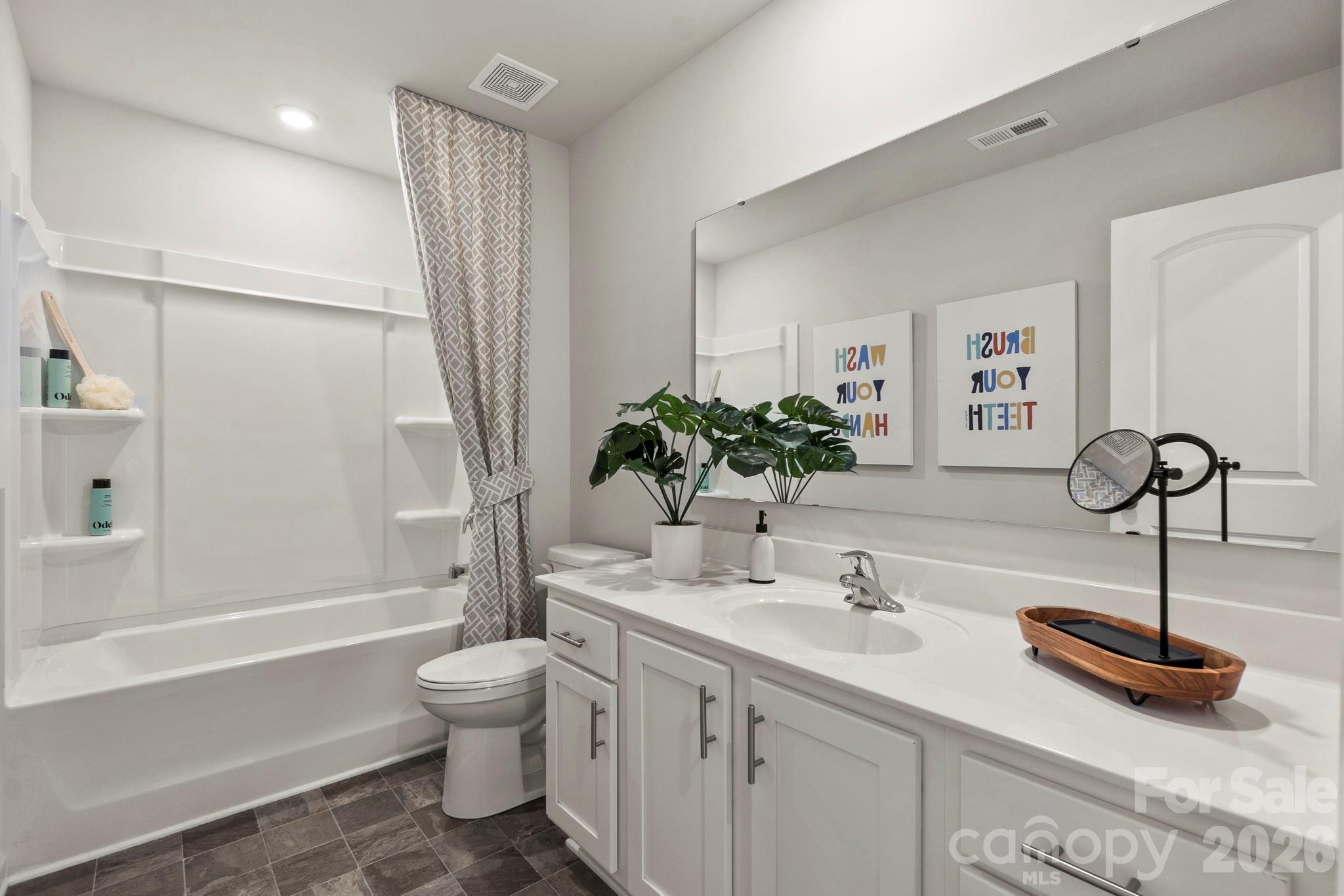 8034 Midas Lane Locust, NC 28097 - Photo 25 of 27 a bathroom with a sink a toilet and a large mirror
