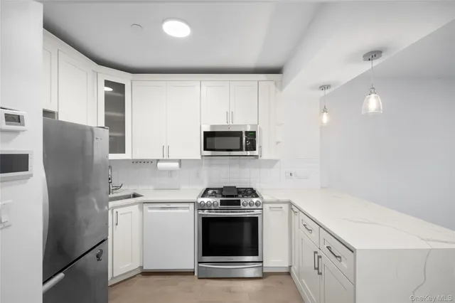 a kitchen with stainless steel appliances a refrigerator stove and microwave