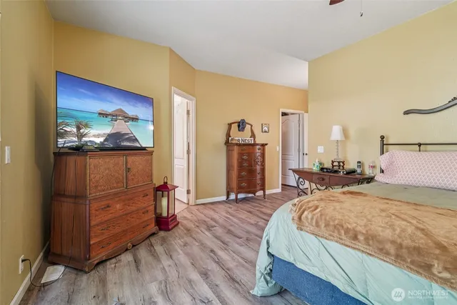 a bedroom with a bed and large mirror on the dresser