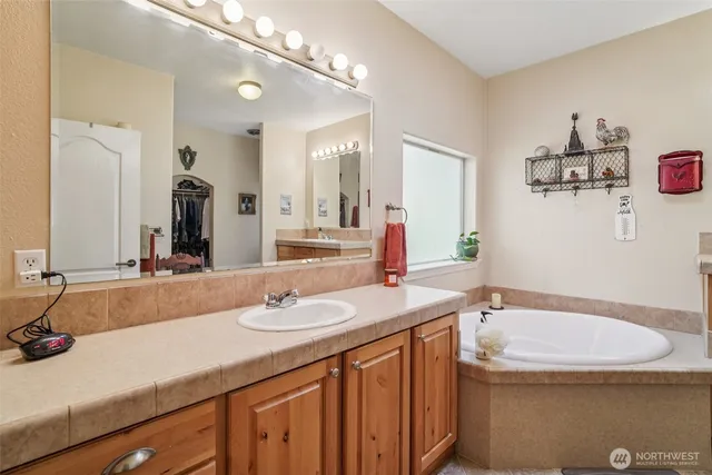 a bathroom with a granite countertop sink a large mirror and a shower
