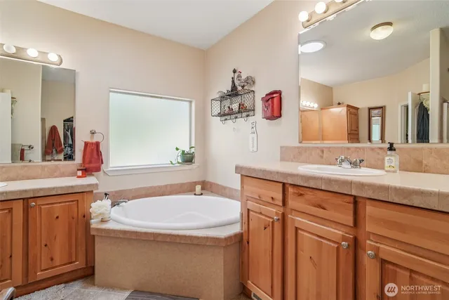 a bathroom with a granite countertop sink a large mirror and a shower
