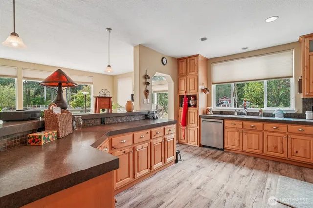 a kitchen with stainless steel appliances granite countertop sink stove and wooden cabinets