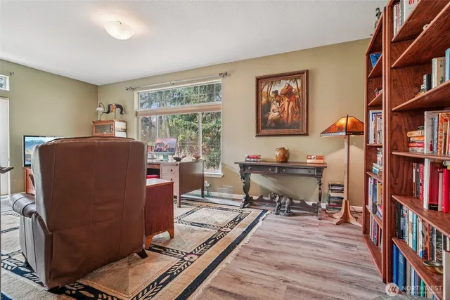 a living room with furniture a bookshelf and a window