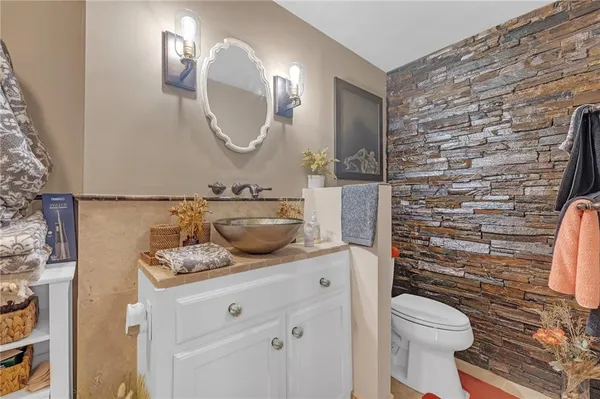 a bathroom with a granite countertop toilet sink and mirror