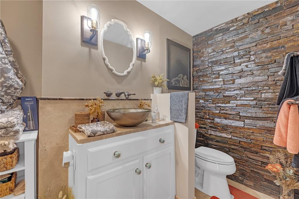 30 5th Street Northeast, Unit 102 Atlanta, GA 30308 - Photo 12 of 25 a bathroom with a granite countertop toilet sink and mirror