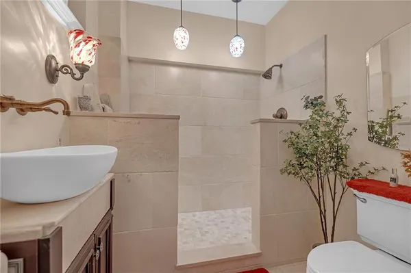 a bathroom with a sink a toilet and shower