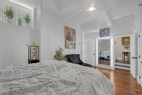 a bedroom with a large bed and wooden floor