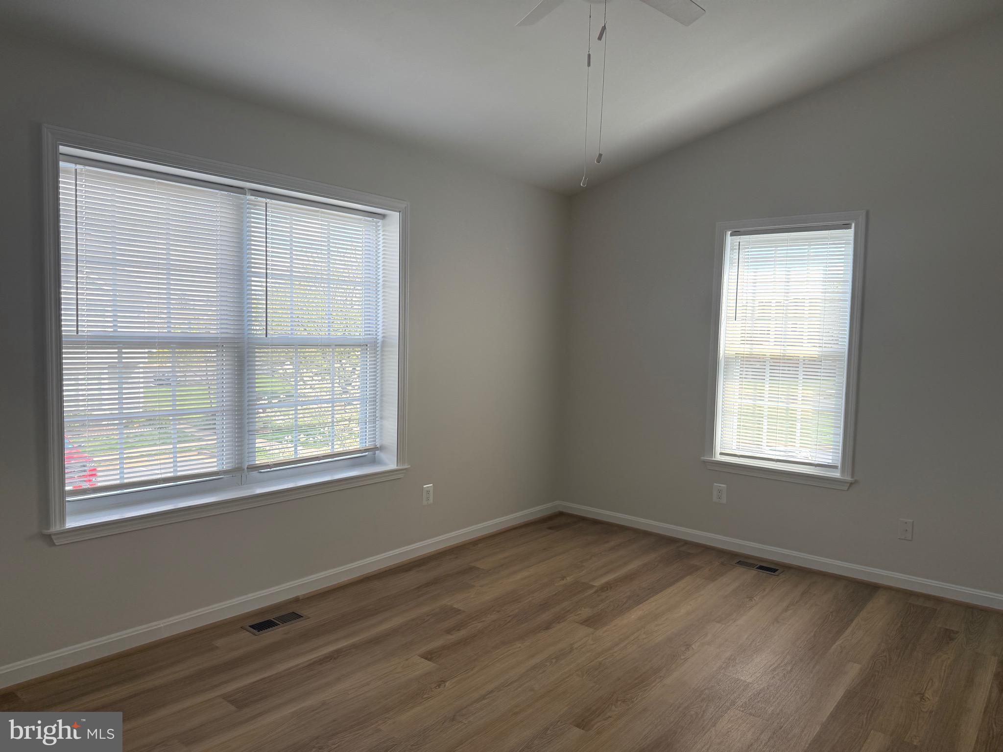 21681 Hazelnut Square, Unit 168 Sterling, VA 20164 - Photo 23 of 35 a view of an empty room with wooden floor and a window