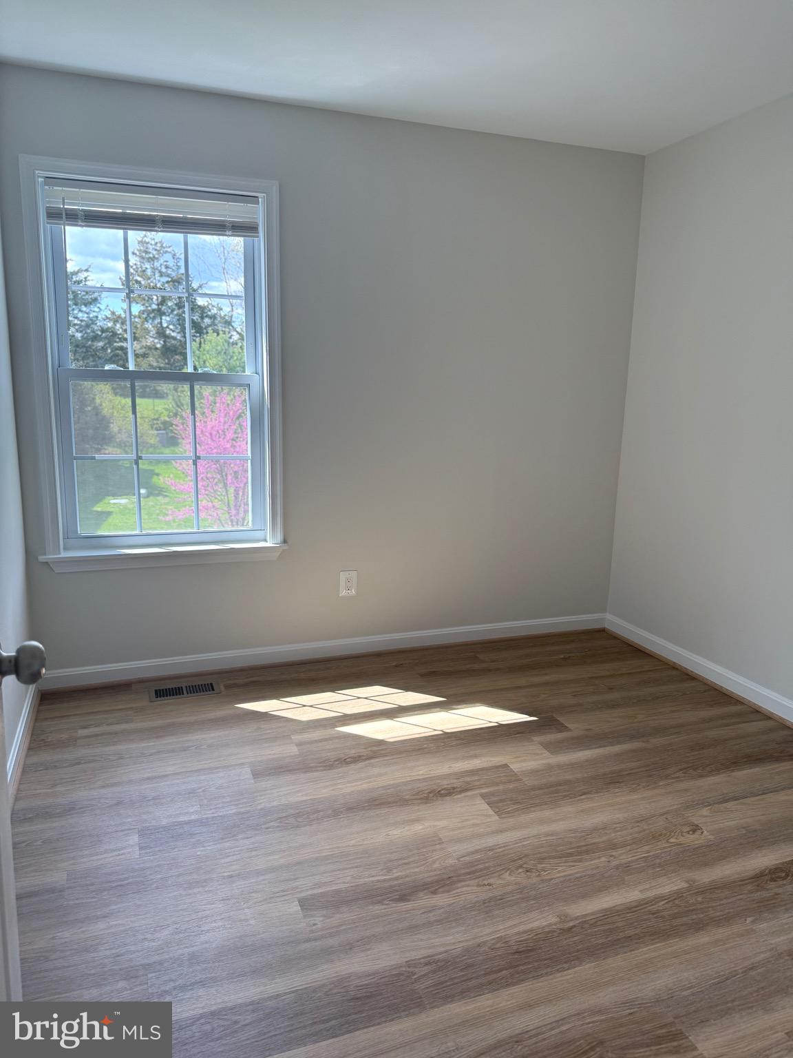 21681 Hazelnut Square, Unit 168 Sterling, VA 20164 - Photo 26 of 35 a view of an empty room with wooden floor and a window