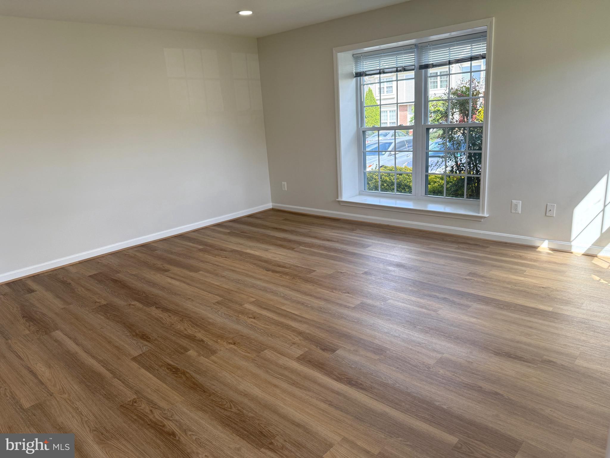 21681 Hazelnut Square, Unit 168 Sterling, VA 20164 - Photo 28 of 35 a view of an empty room with wooden floor and a window