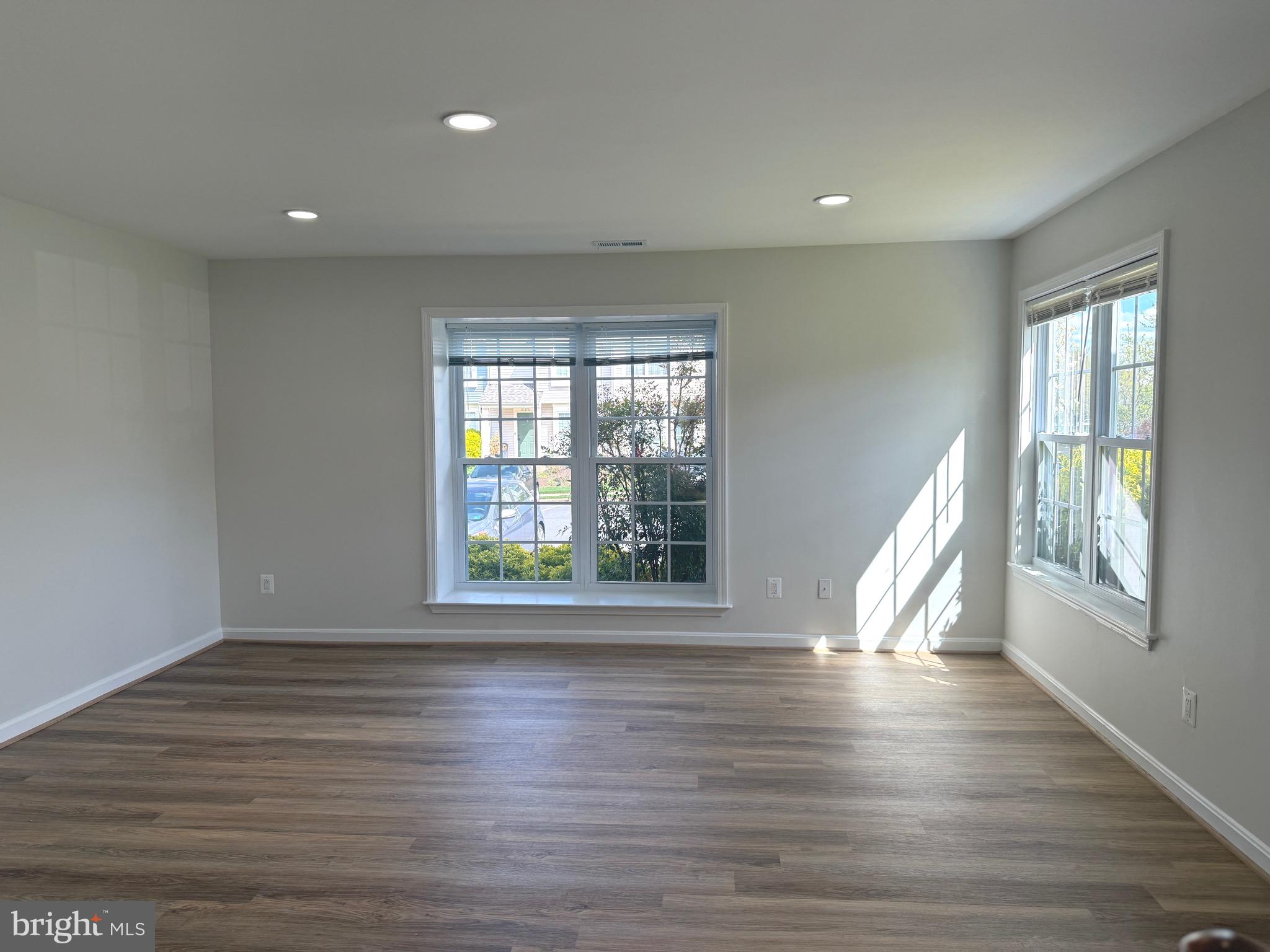 21681 Hazelnut Square, Unit 168 Sterling, VA 20164 - Photo 5 of 35 a view of an empty room with wooden floor and a window