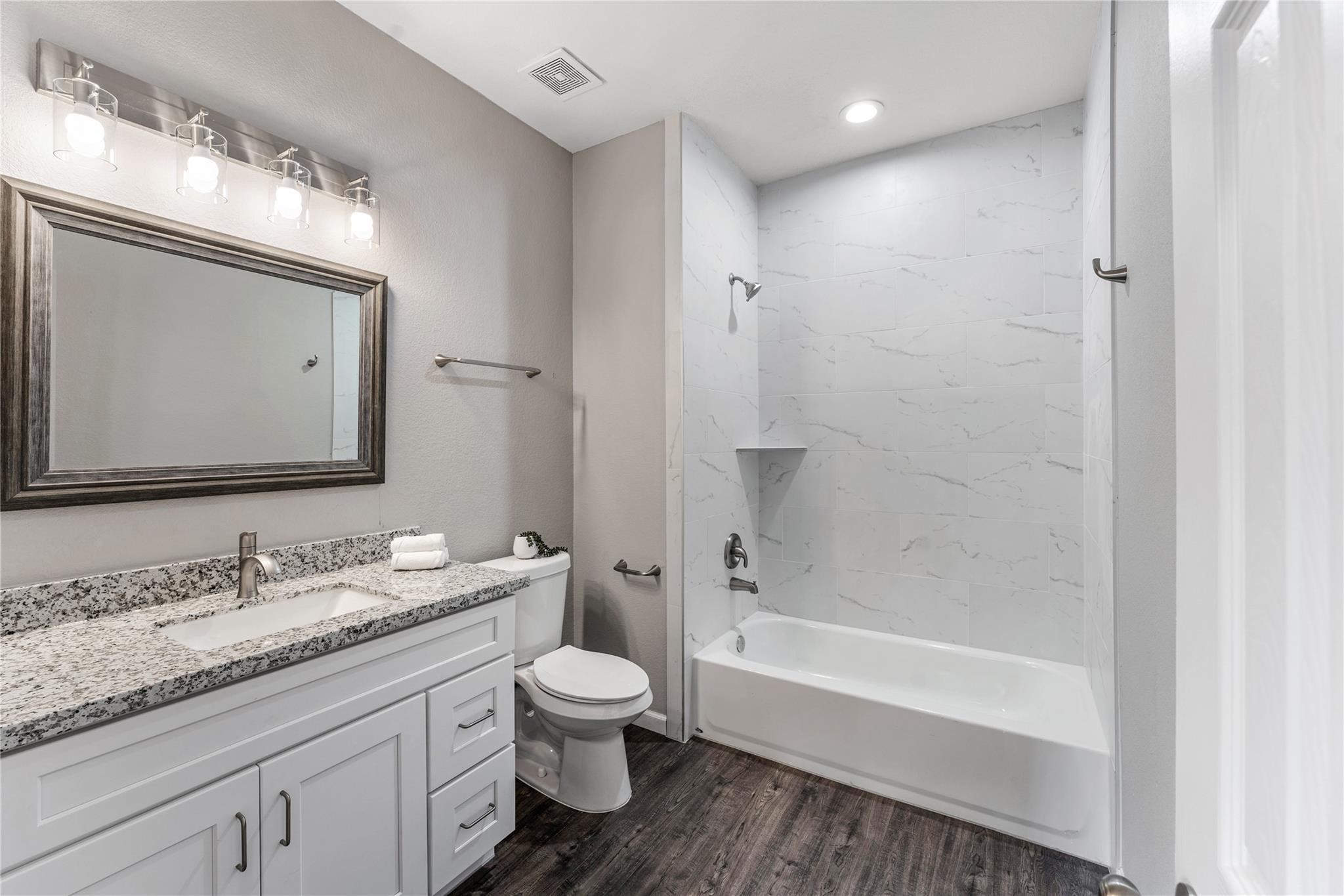 5218 Jezebel Street, Unit B Houston, TX 77033 - Photo 23 of 31 a bathroom with a granite countertop sink toilet and shower