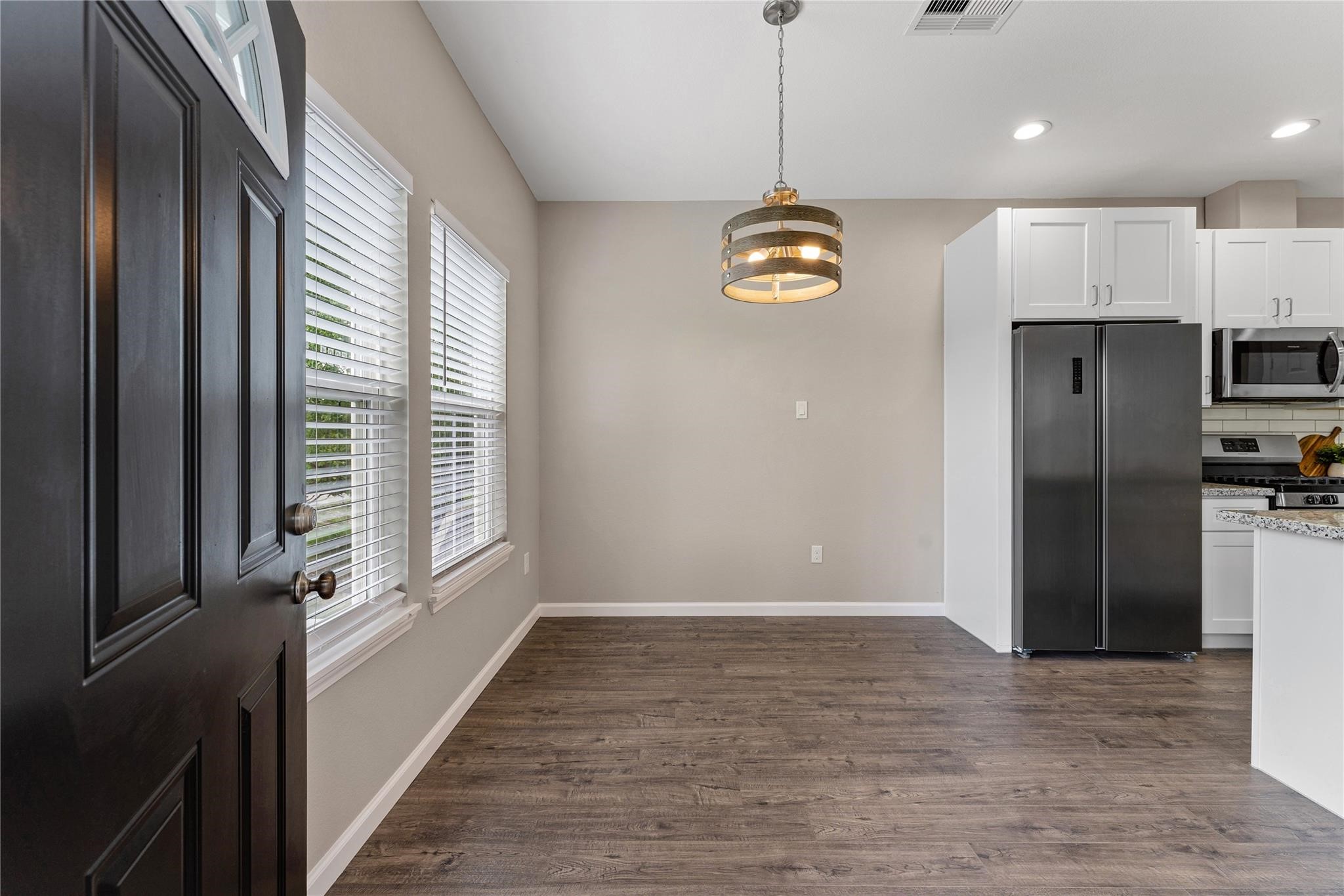 5218 Jezebel Street, Unit B Houston, TX 77033 - Photo 6 of 31 a view of a kitchen with a refrigerator wooden floor and windows