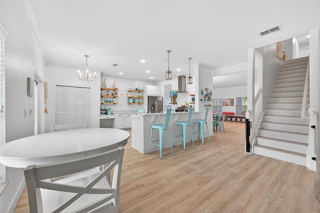 20930 Sullivan Ranch Boulevard Mount Dora, FL 32757 - Photo 13 of 41 a room with stainless steel appliances kitchen island granite countertop a table chairs and a refrigerator