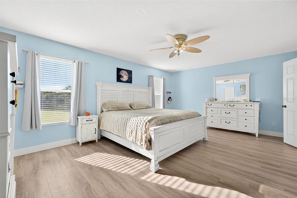 20930 Sullivan Ranch Boulevard Mount Dora, FL 32757 - Photo 18 of 41 a bedroom with a bed and a chandelier