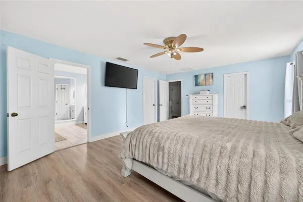 a spacious bedroom with a bed and a flat screen tv
