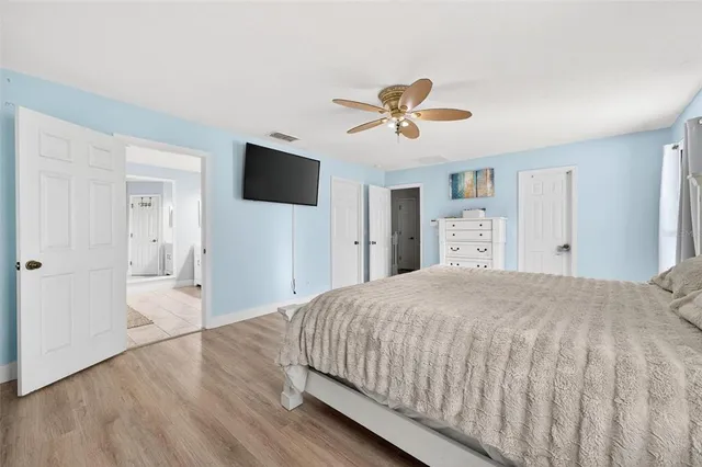 a spacious bedroom with a bed and a flat screen tv