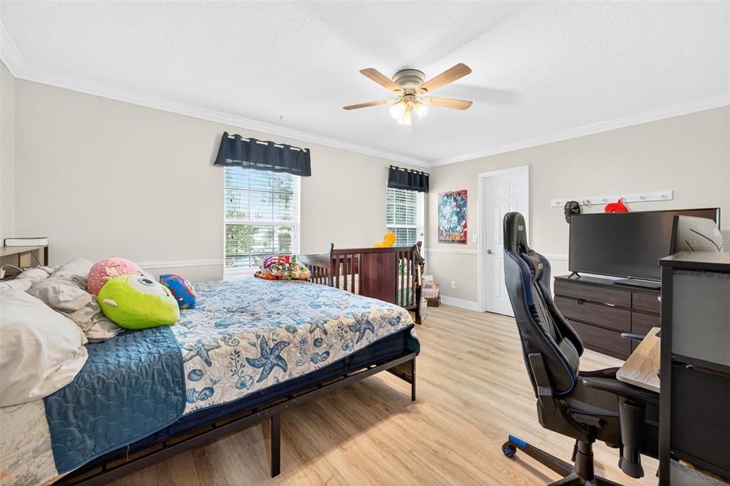 20930 Sullivan Ranch Boulevard Mount Dora, FL 32757 - Photo 33 of 41 a bedroom with a bed and wooden floor