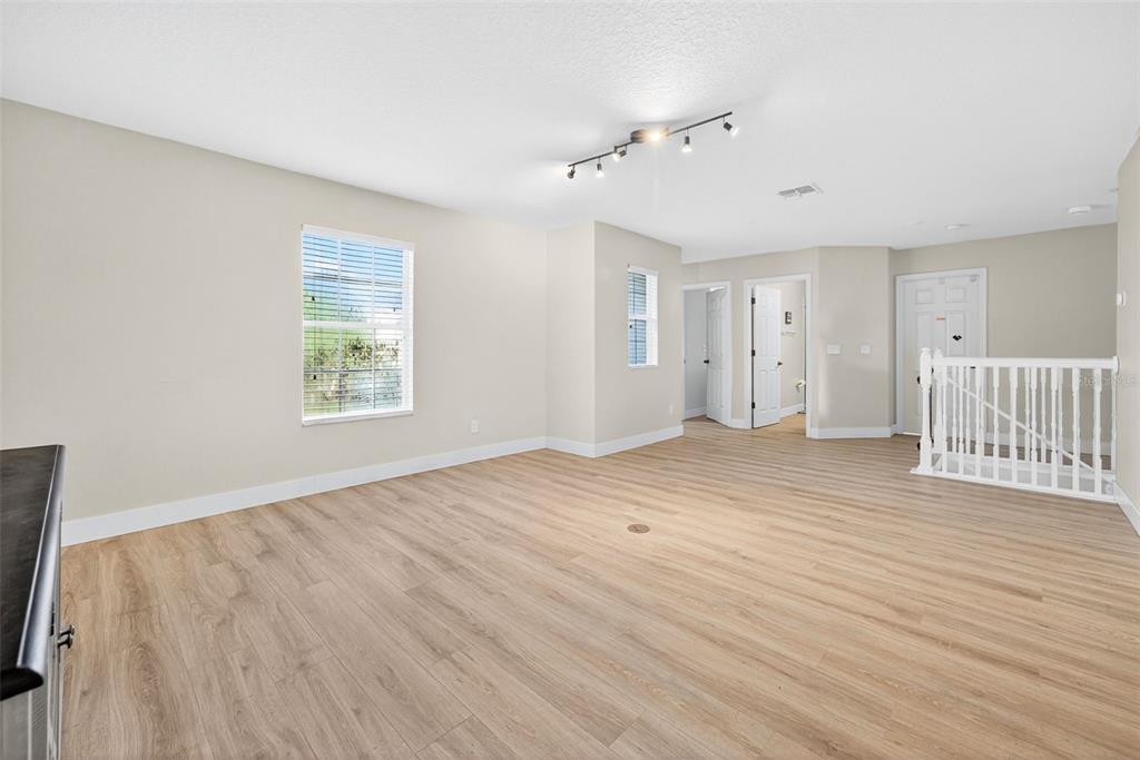20930 Sullivan Ranch Boulevard Mount Dora, FL 32757 - Photo 37 of 41 an empty room with wooden floor and windows