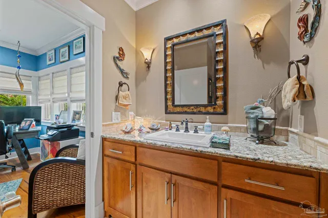 a bathroom with a granite countertop sink a mirror and shower