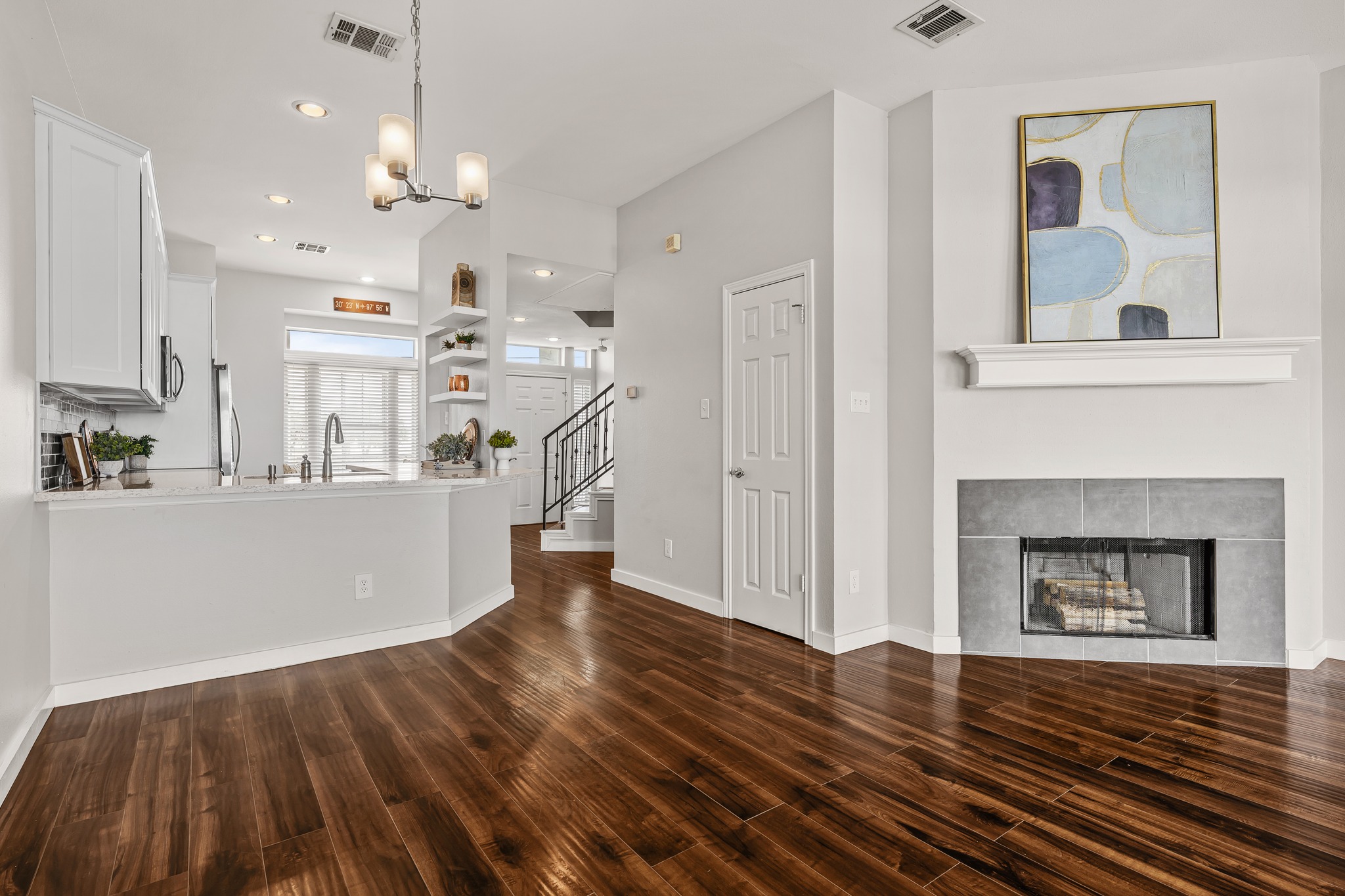 2918 Ranch Road 620 North, Unit S242 Austin, TX 78734 - Photo 19 of 35 Rich hardwood flooring flows through this bright, open-concept living space, featuring a cozy fireplace.