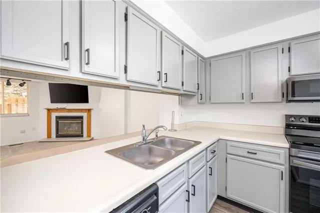 a kitchen with white cabinets sink and stainless steel appliances