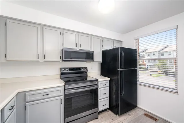a kitchen with a refrigerator stove and cabinets