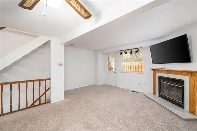 a view of an empty room with a fireplace and a window
